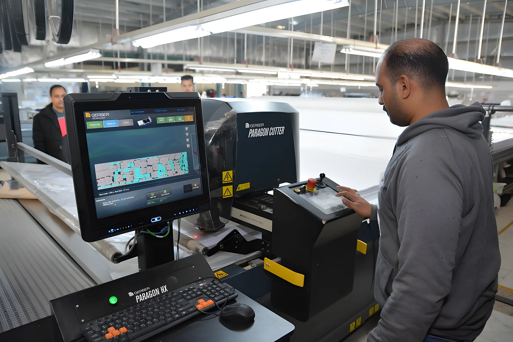 An operator at the control screen of a Gerber Paragon automated cutter